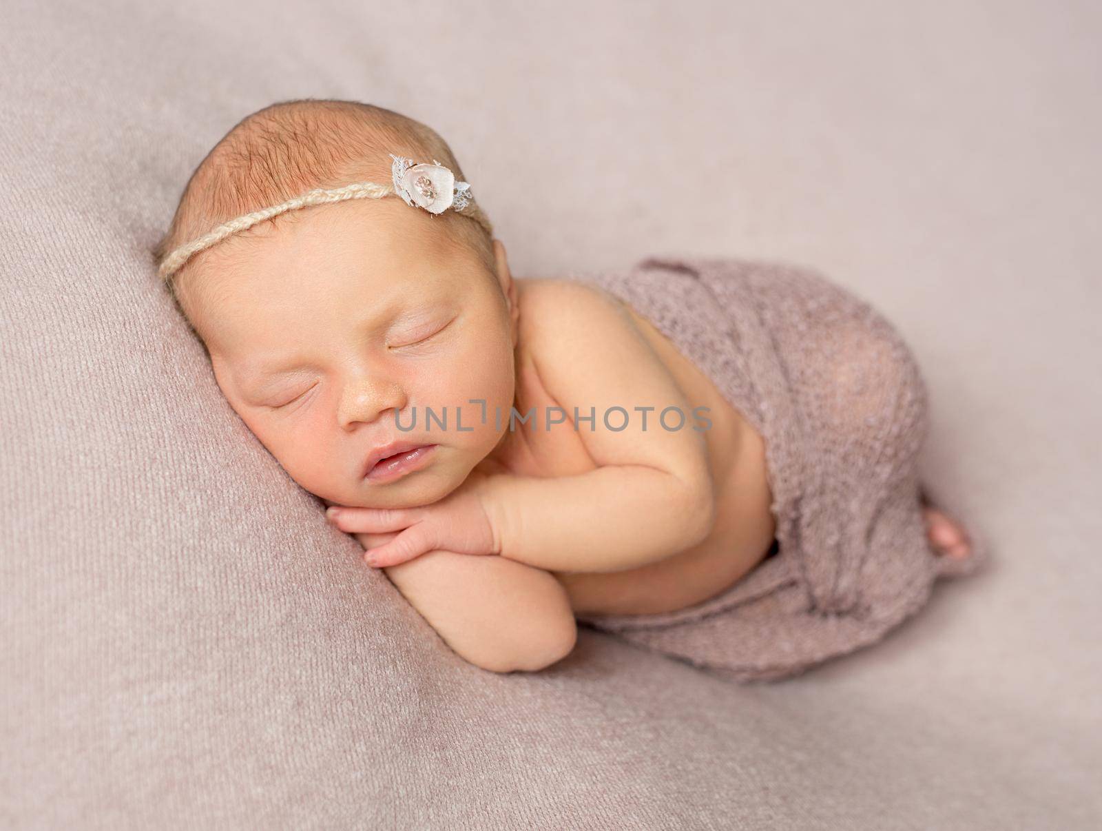 bare sweet sleeping newborn girl covered with knitted shawl