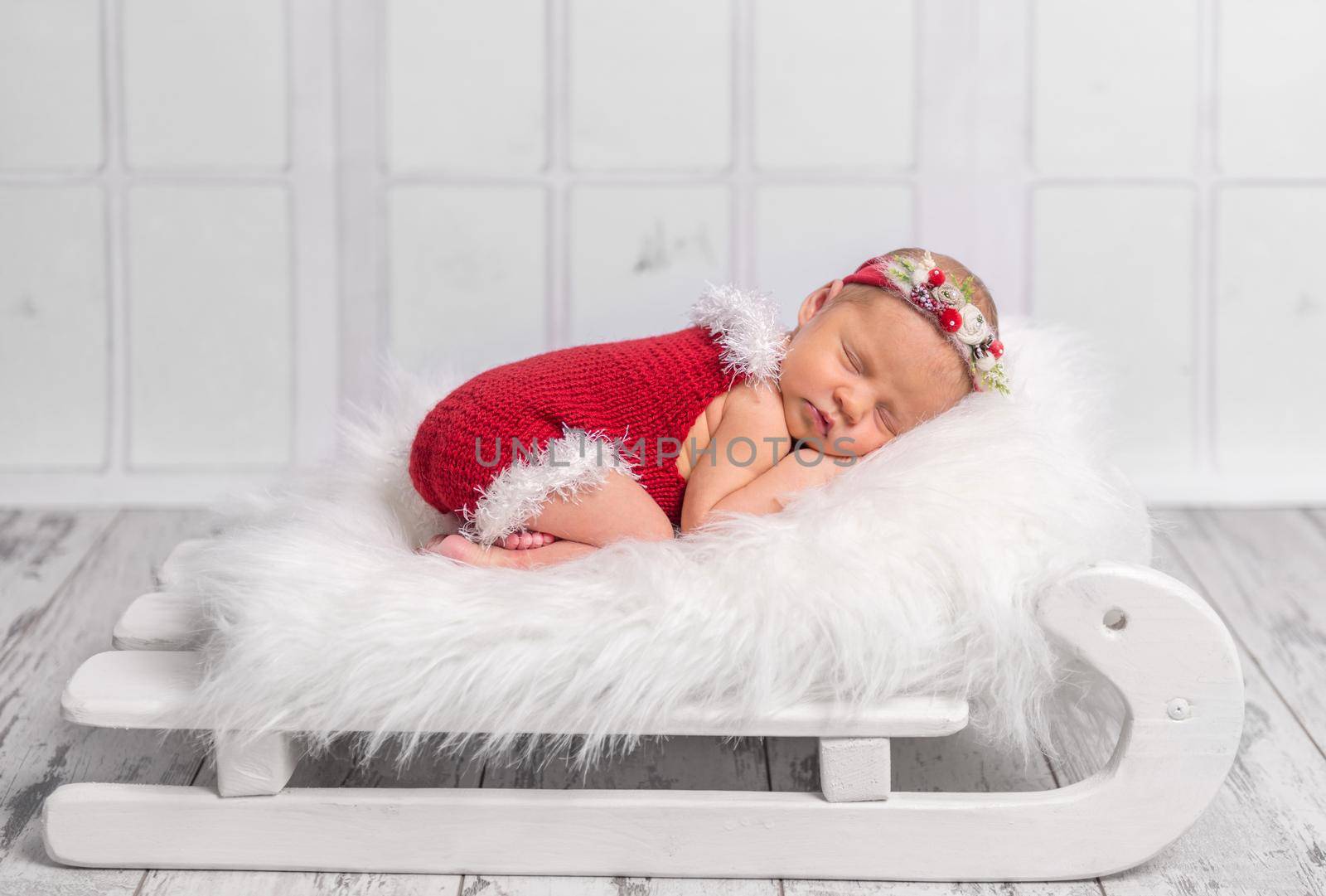 beautiful newborn in red romper on sleigh cot by tan4ikk1