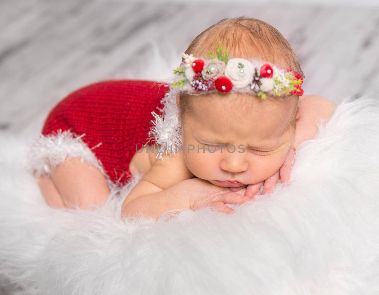 lovely newborn girl in red romper sleeping on fluffy blanket by tan4ikk1