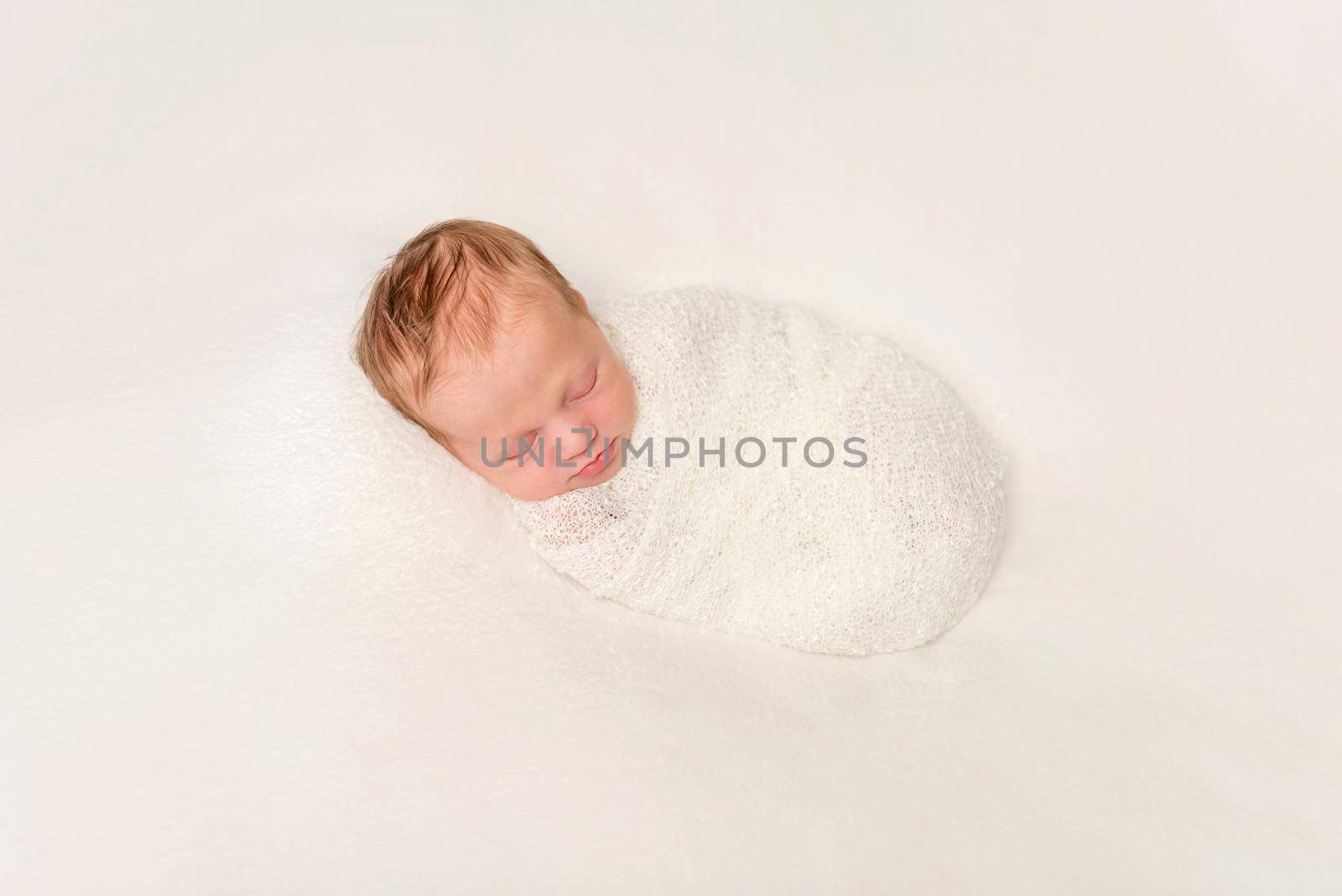 funny swaddled in white costume newborn baby sleeping on blanket