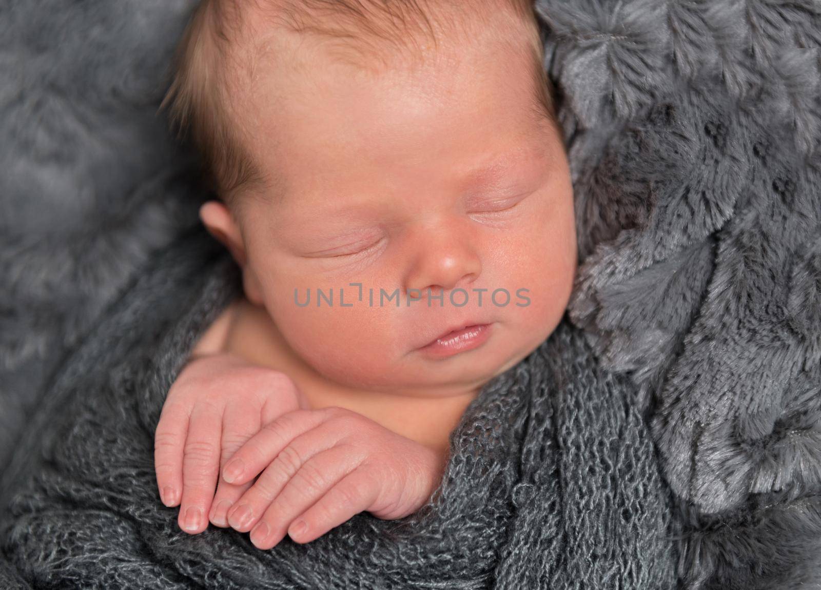 Sweet dreams of a newborn baby, pressing his hands to himself, closeup