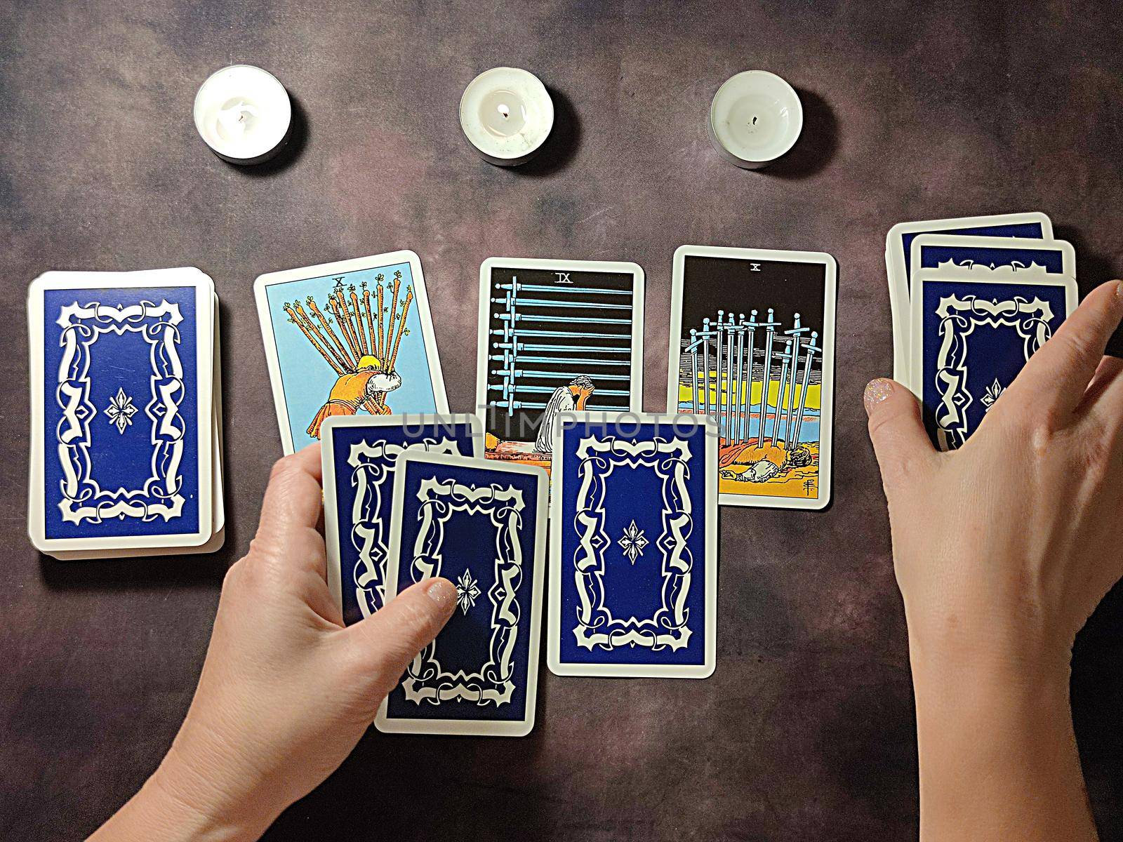 female hands spread tarot cards on the table, solitaire layout.