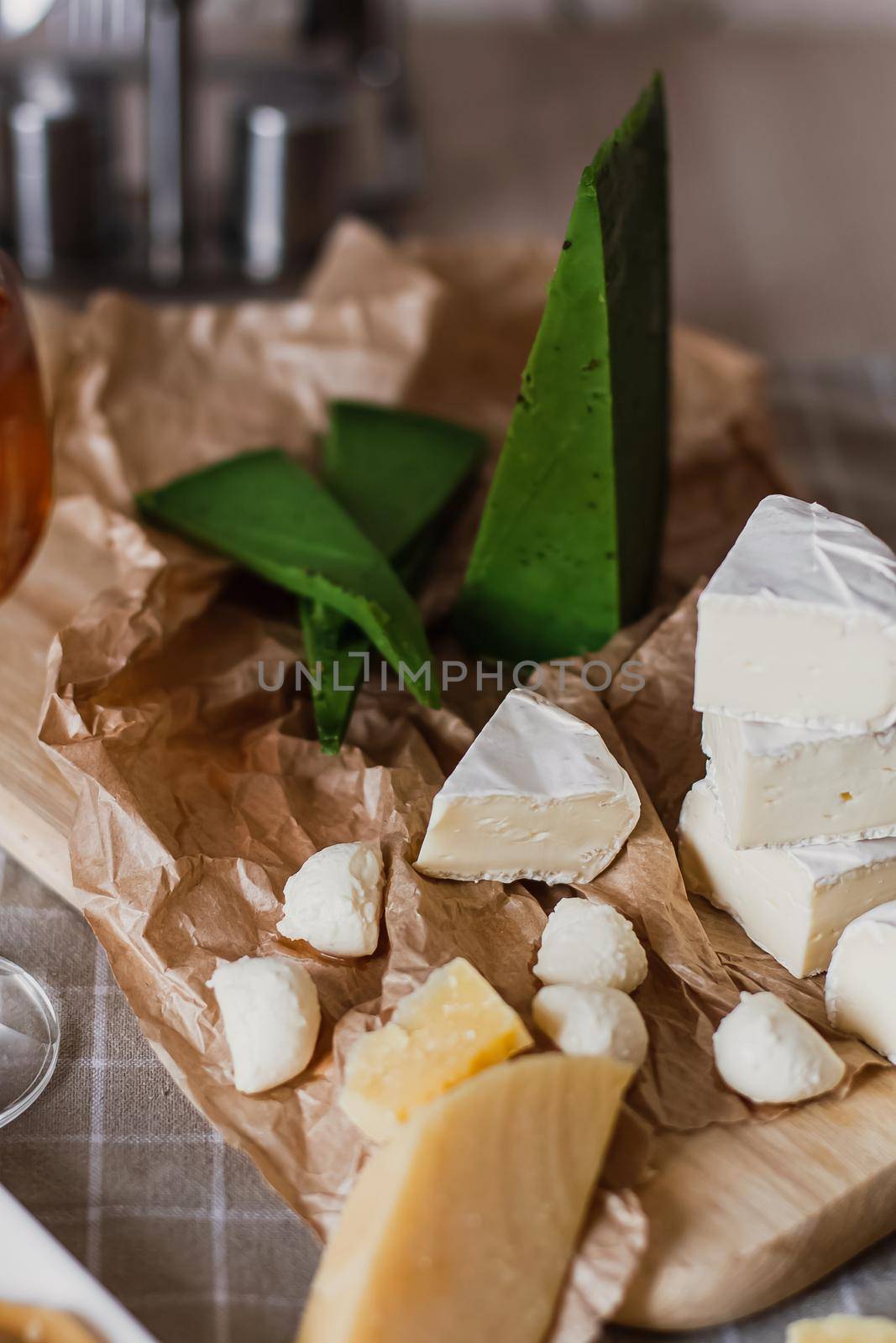 Delicious cheeses on a board with honey and wine on a paper background by mmp1206