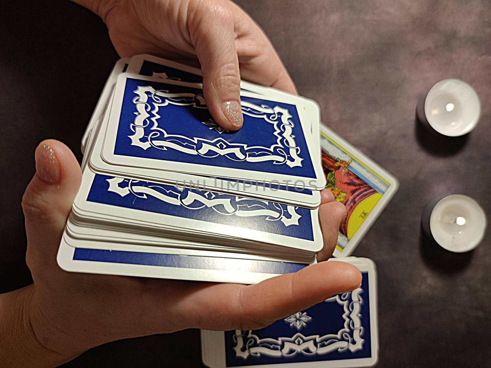 female hands shuffle tarot cards, solitaire layout.