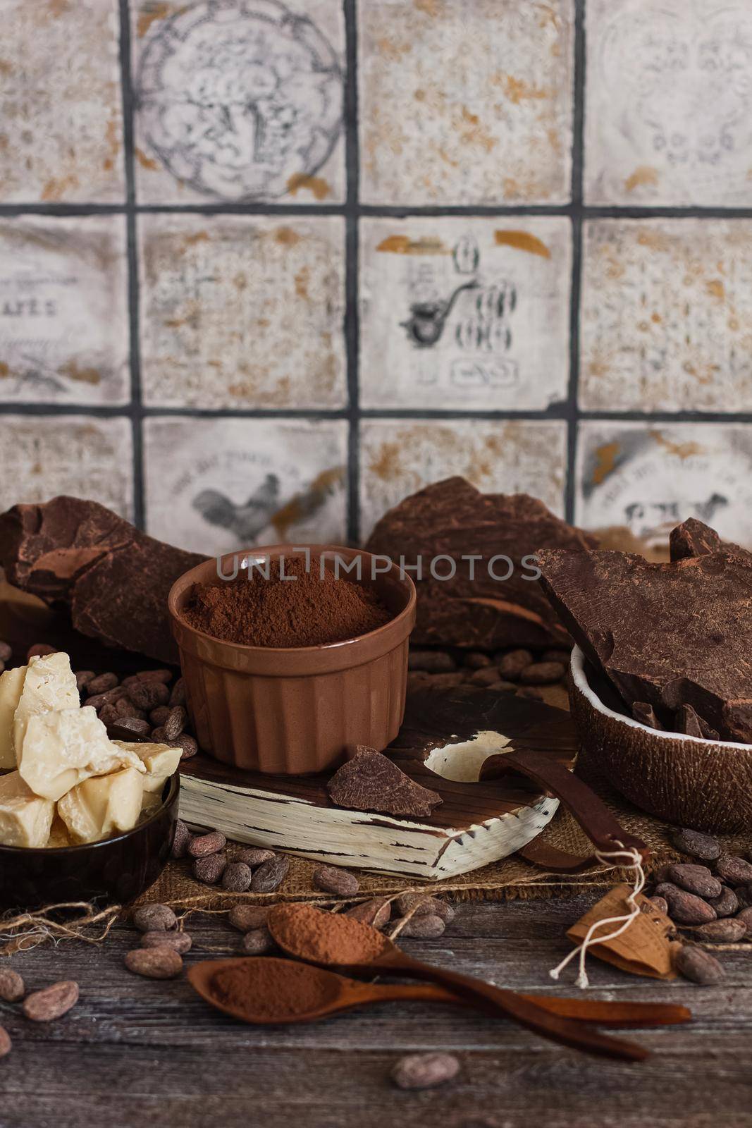 Unsweetened baking block chocolate, cocoa powder, cocoa butter and cocoa beans on old wooden background by mmp1206