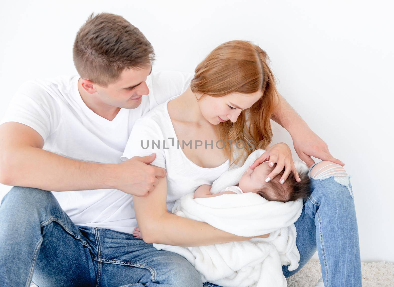 Father, mother and sleeping baby girl at home