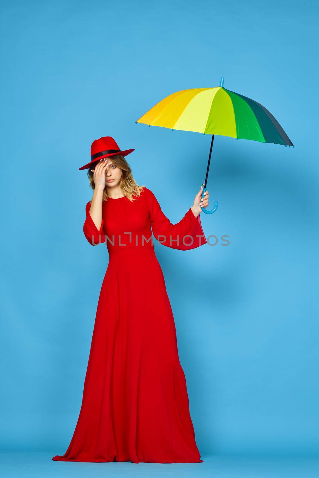 woman in red dress multicolored umbrella blue background by Vichizh