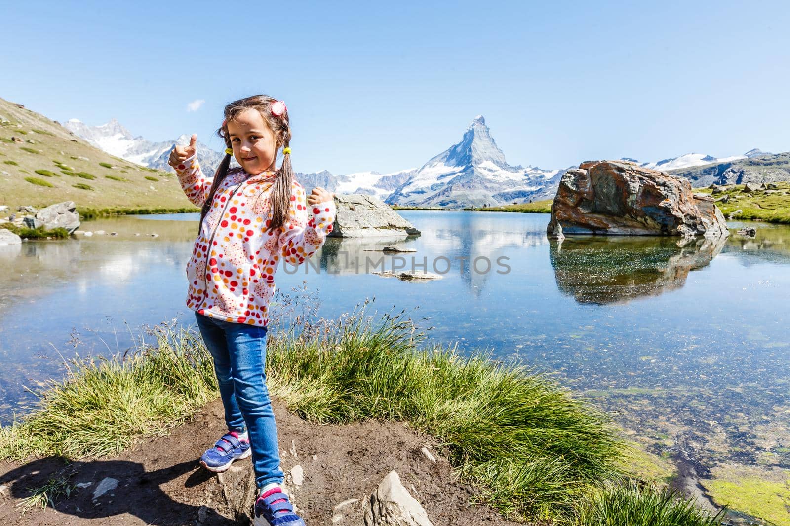 Hiking in the swiss alps with flower field and the Matterhorn peak in the background