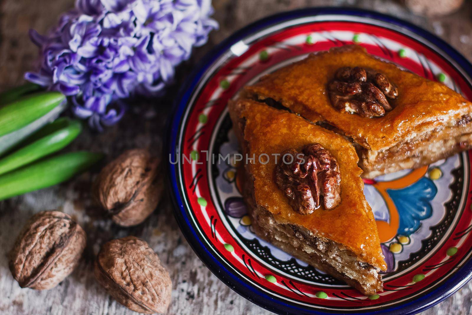 Assorted baklava. A Turkish ramadan arabic sweet dessert on a decorative plate, with coffee cup in the background. Middle eastern food baklava with nuts and honey syrup by mmp1206
