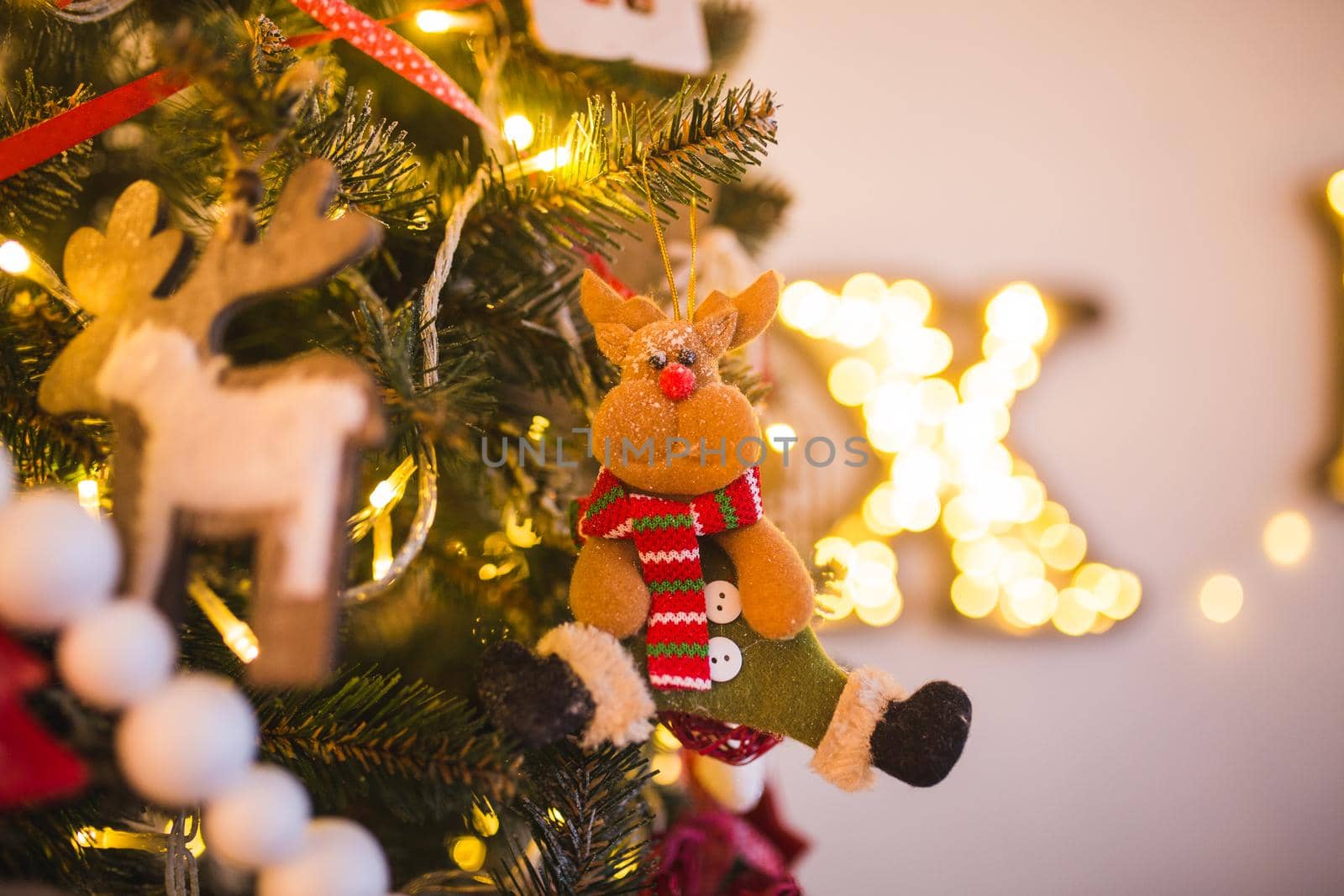 Christmas tree decorated with toys, balls, tinsel, funny baby animals , flowers close up on a background of green fir and of the magic by Tomashevska