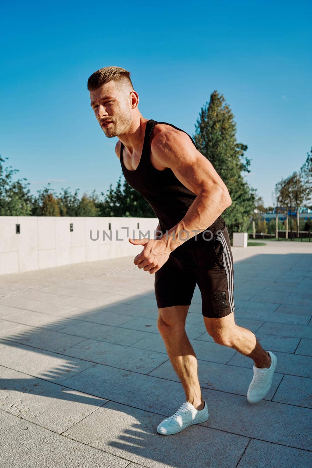 sporty man in the park with dumbbells workout fitness by Vichizh