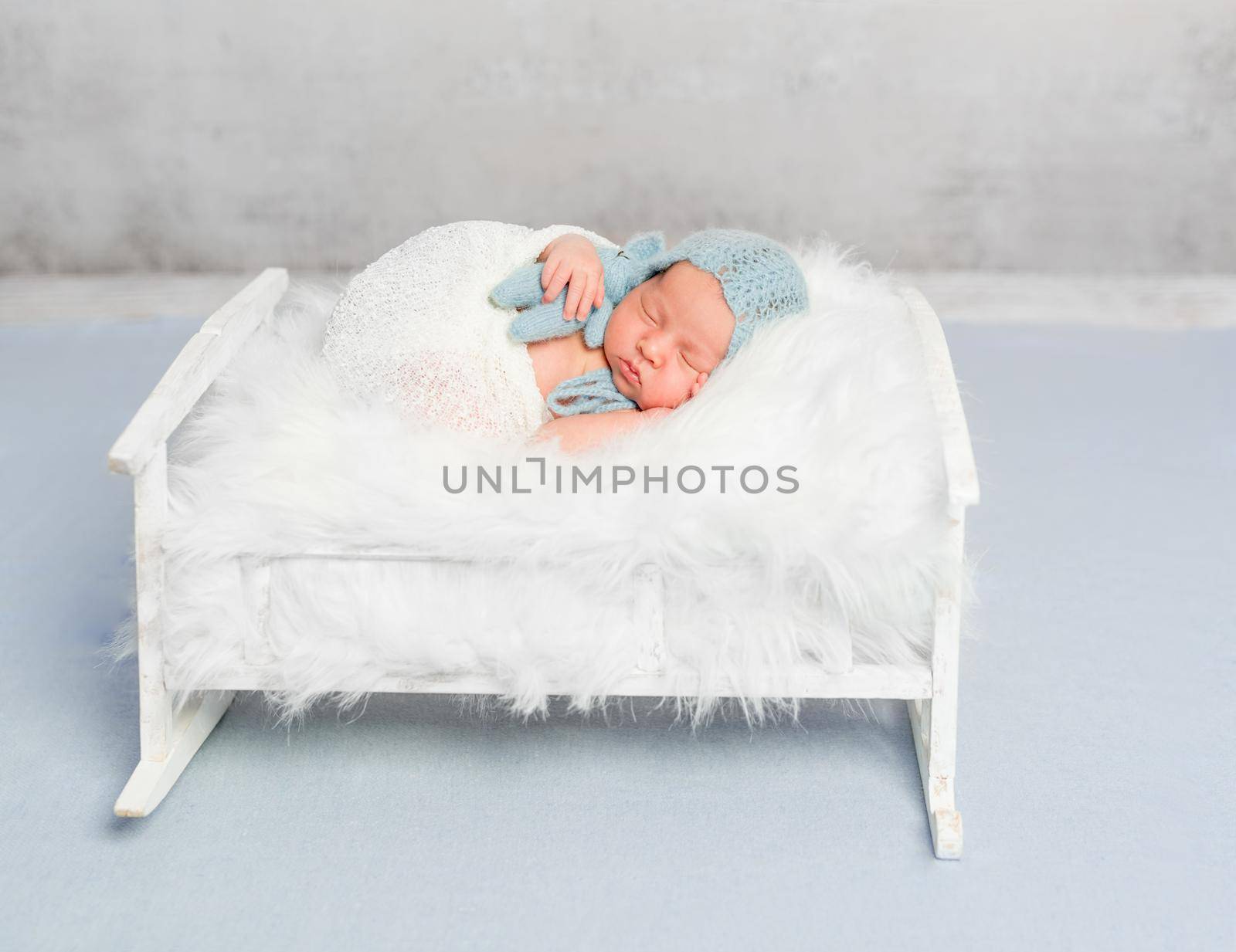 dreamy newborn boy holding toy sleeps by tan4ikk1