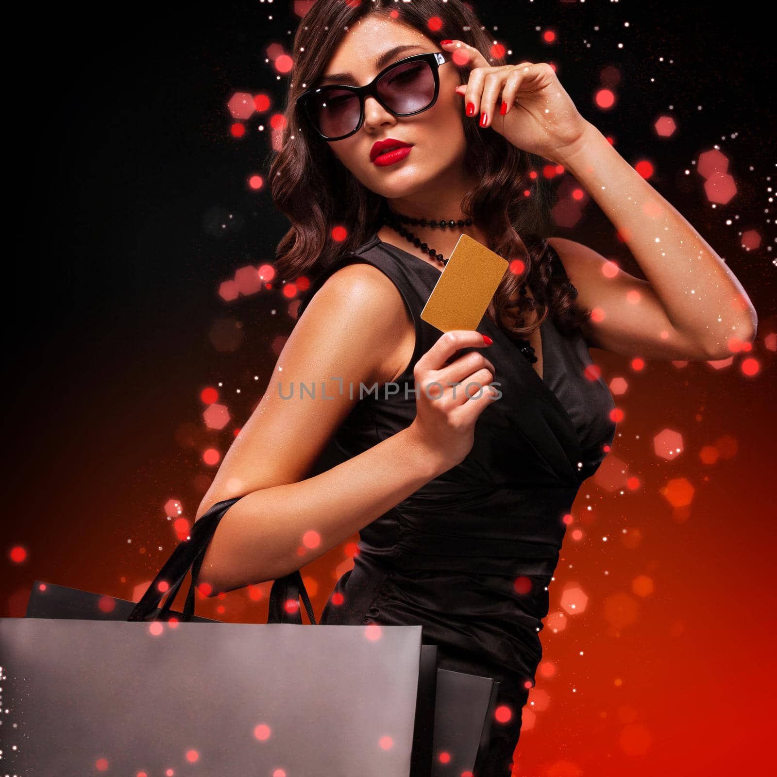 Beautiful young woman make shopping in black friday holiday. Girl with black bag on dark background.