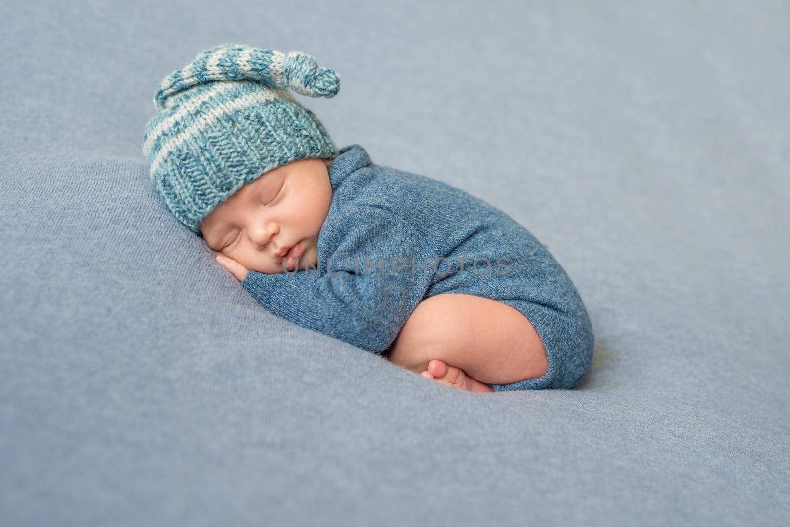 sleeping newborn baby in blue jumpsuit and hat by tan4ikk1
