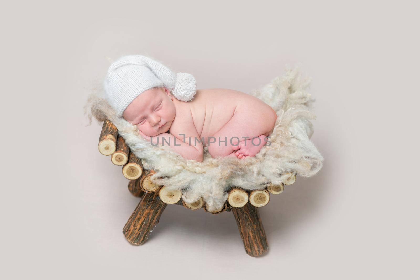 Newborn baby sleeps on a wooden homemade crib