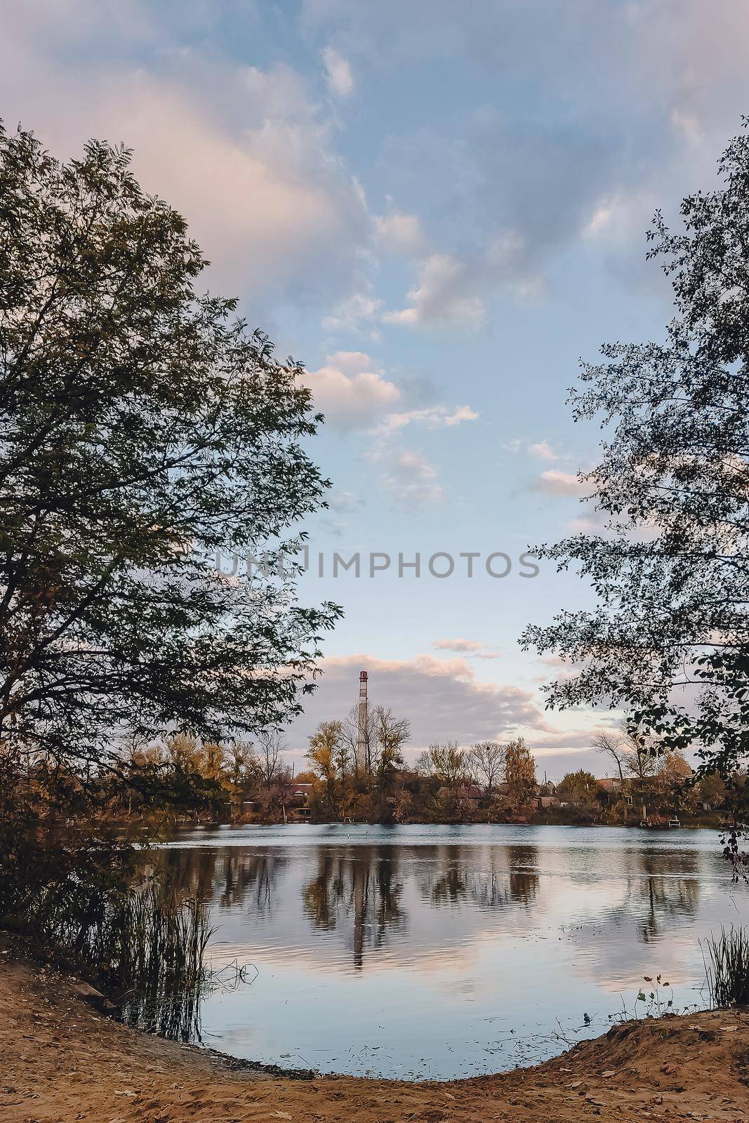 Vivid autumn day. Autumn landscape over river with bright grass on shore. Scenic nature at bright evening with colorful sky and water by mmp1206