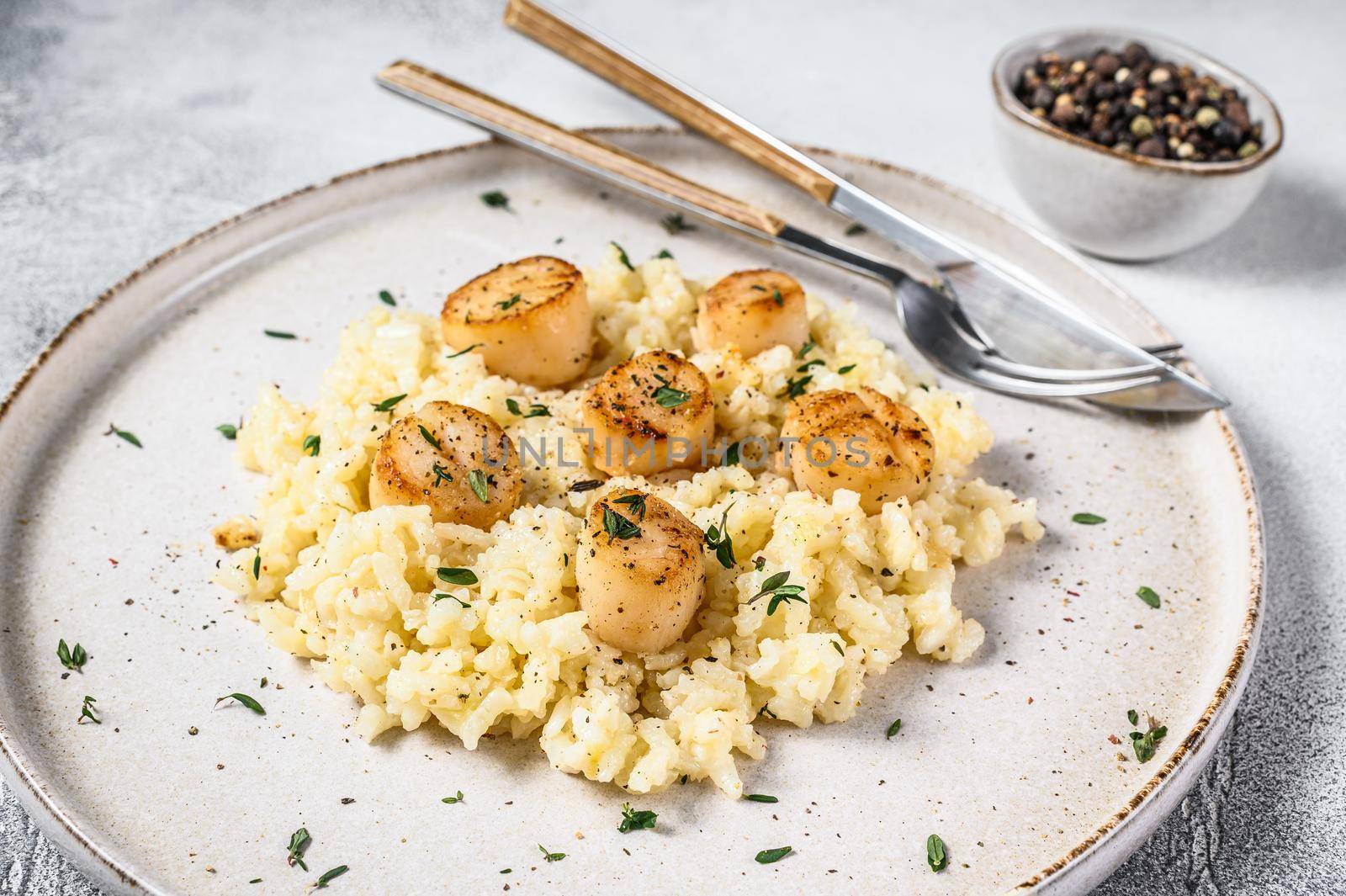 Italian Risotto with pan seared sea scallops. White background. Top view by Composter