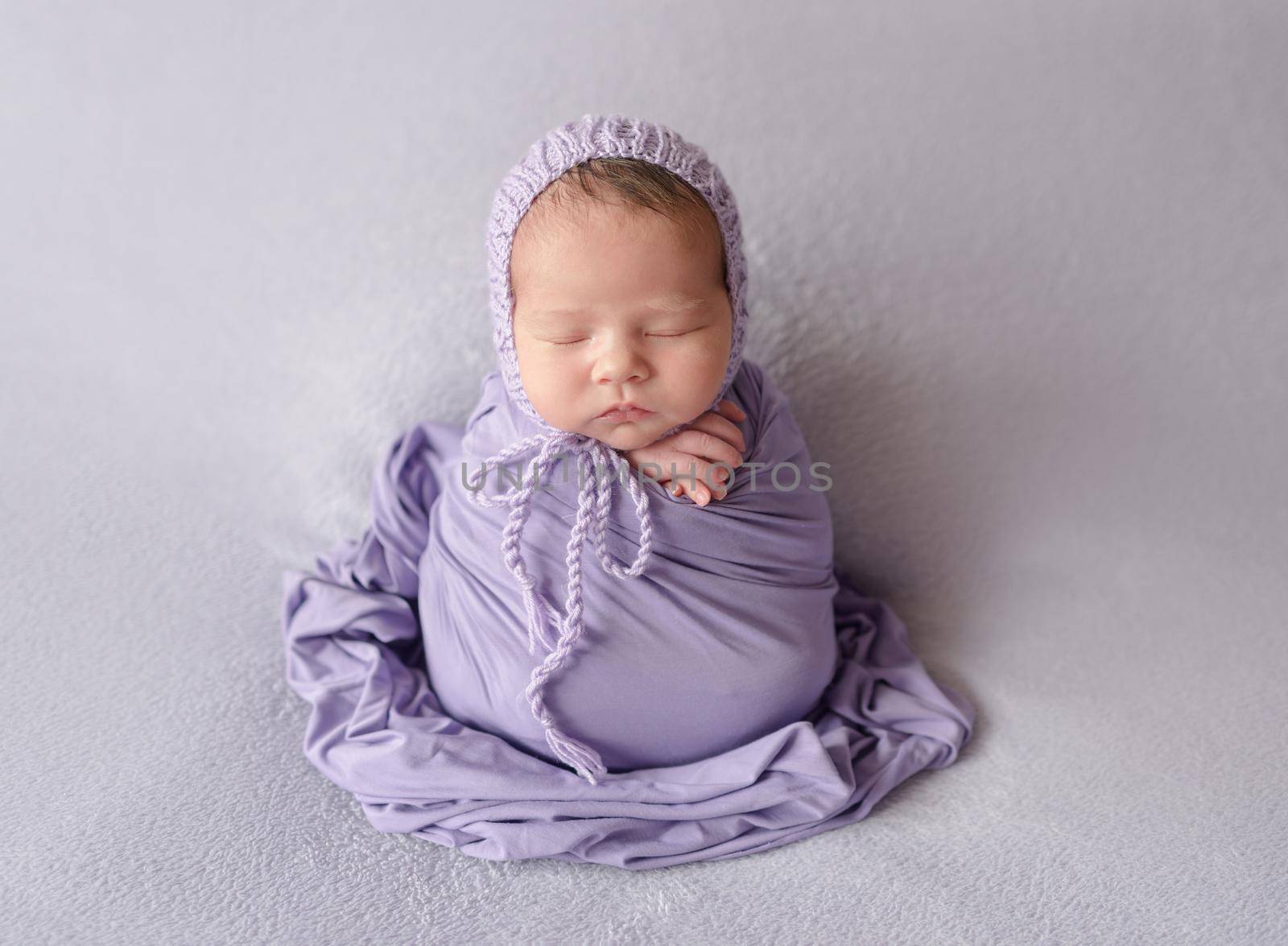 Cute sleeping newborn baby girl in violet