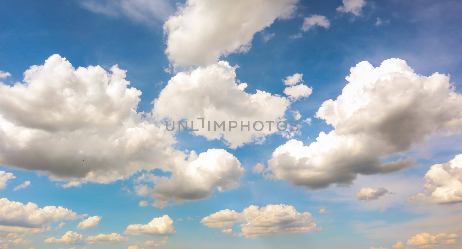 Blue sky with white plump fluffy clouds and sun. Cumulus clouds. Nature weather blue sky. Beautiful background white clouds