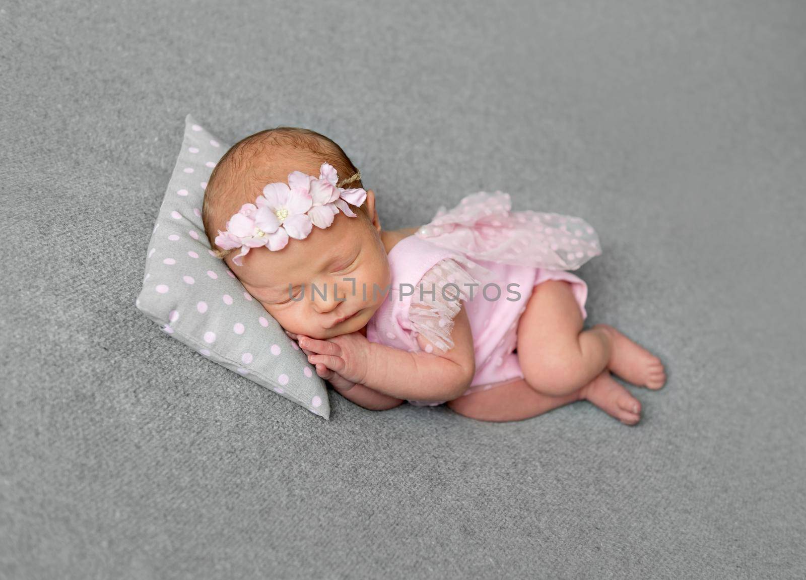 Lovely newborn girl in pink drees sleeping by tan4ikk1