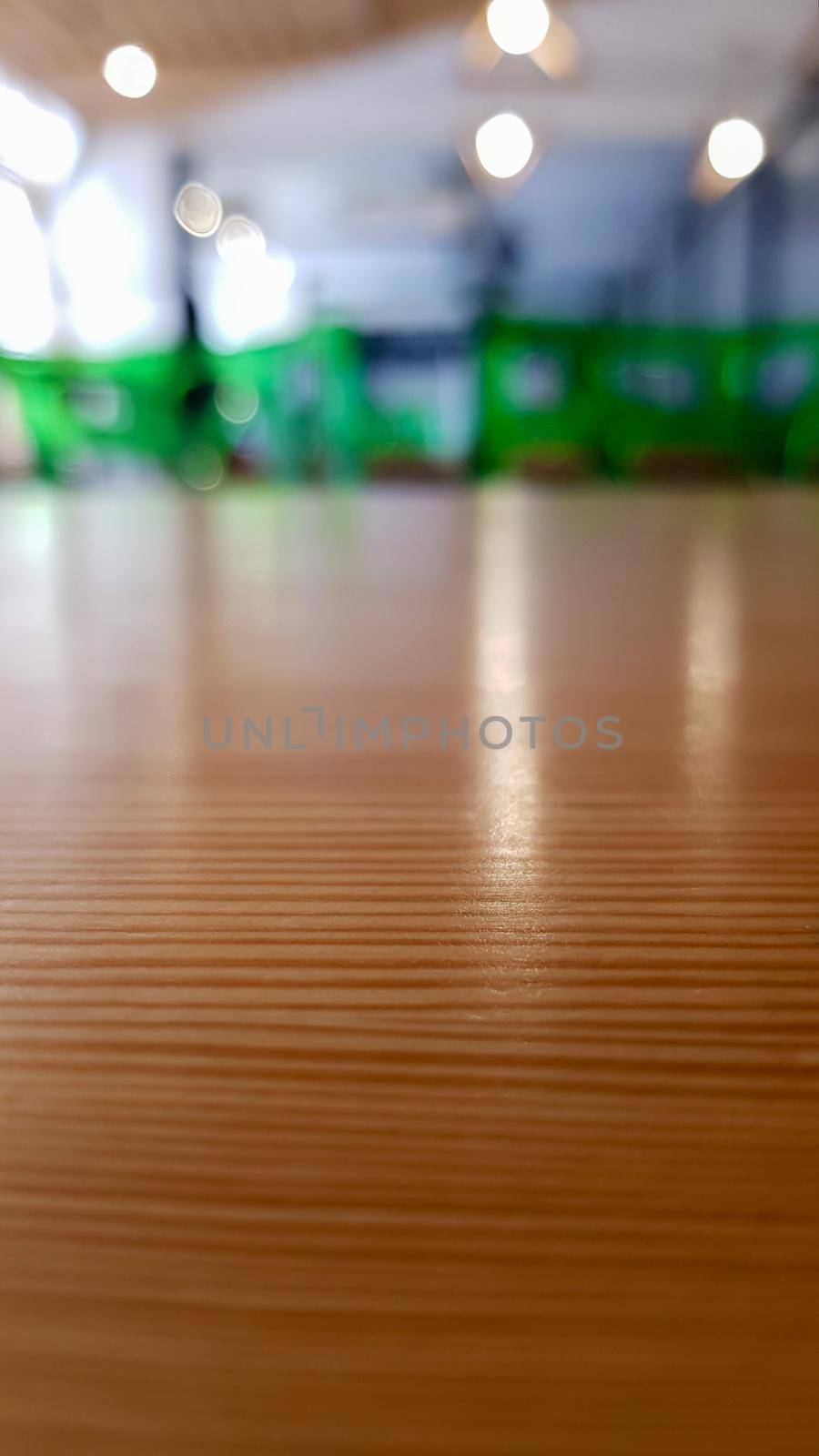 Cafeteria, no people dining room with wooden tables and green chairs. Interior with wood and metal elements. Modern dining areas with window lighting. Ukraine, Kiev - February 19, 2021.