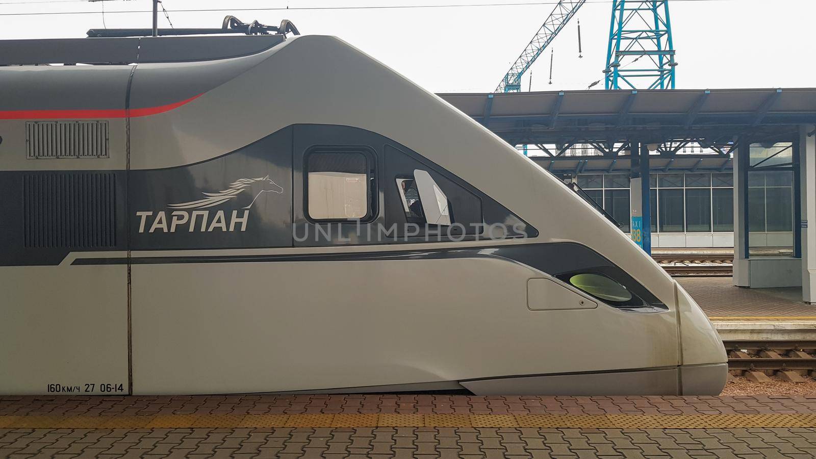 The high-speed passenger electric train Hyundai Rotem Tarpan HRCS2 Intercity stands on the platform of the central railway station in Kiev. Ukrainian railways. Ukraine, Kiev - June 09, 2021