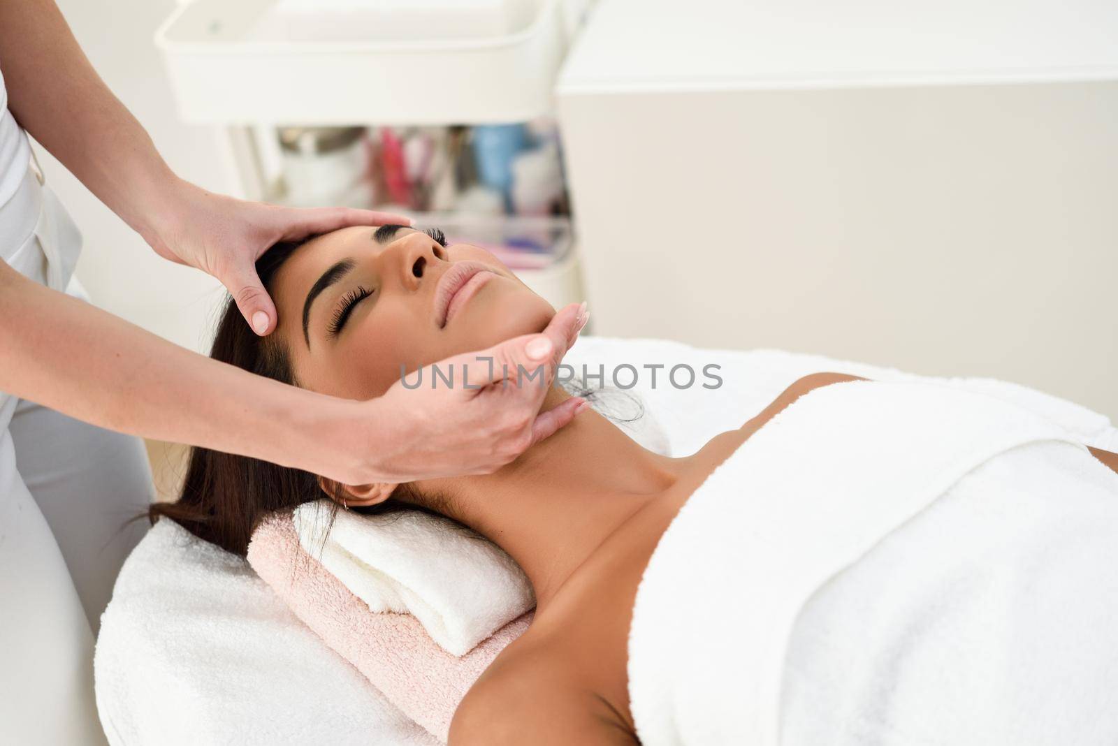 Arab woman receiving head massage in spa wellness center. Beauty and Aesthetic concepts.