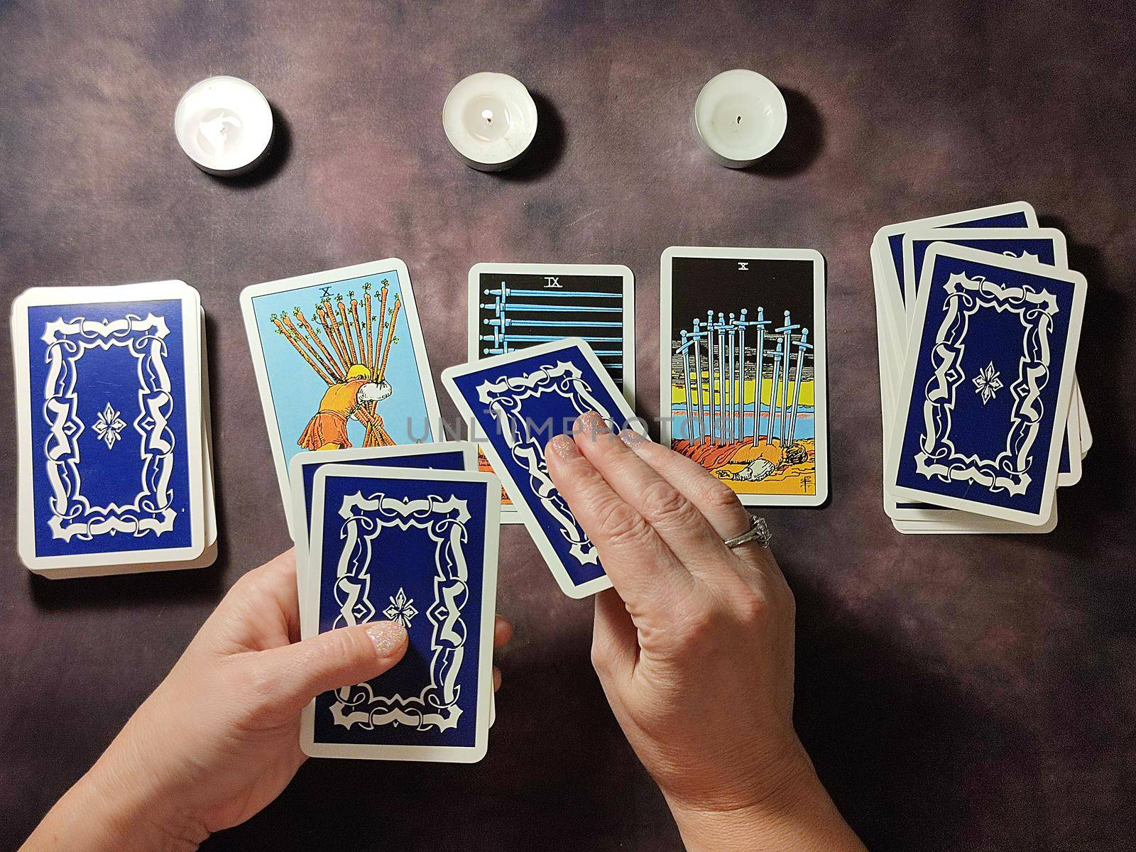 female hands spread tarot cards on the table, solitaire layout.