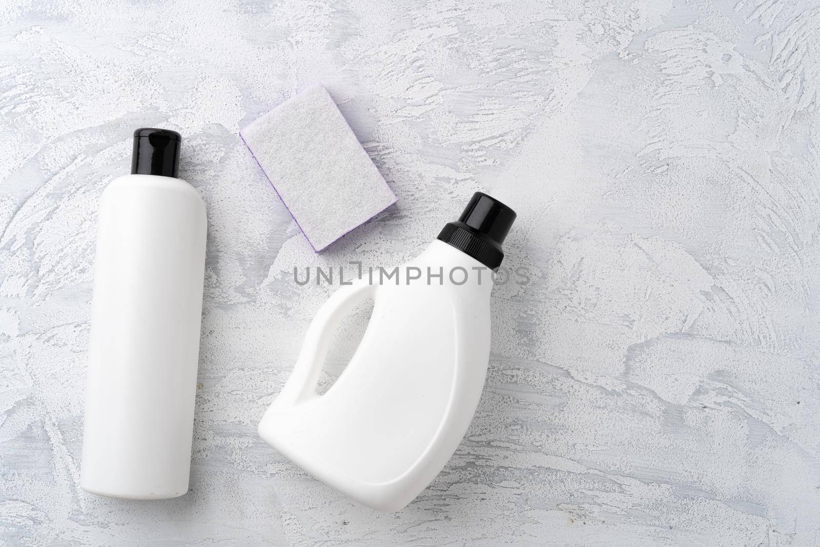 Set of different bottles of liquid detergents top view on grey background