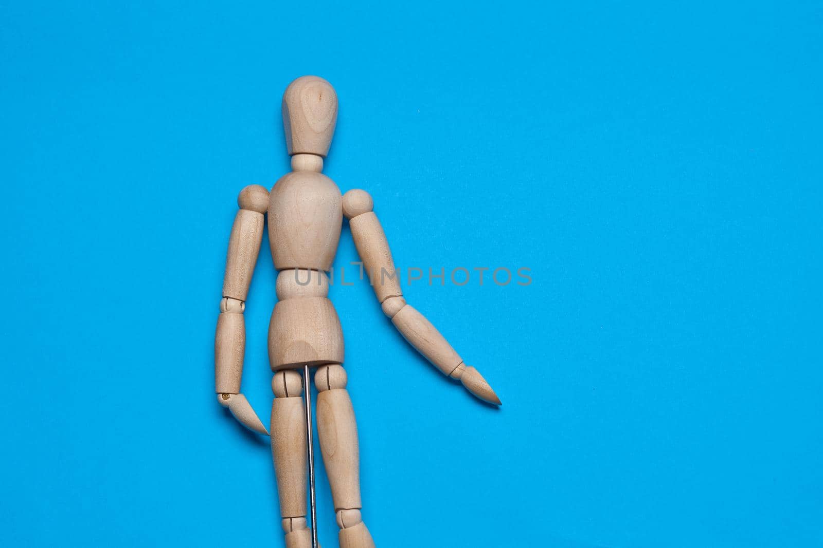 wooden figure mannequin object posing blue background. High quality photo