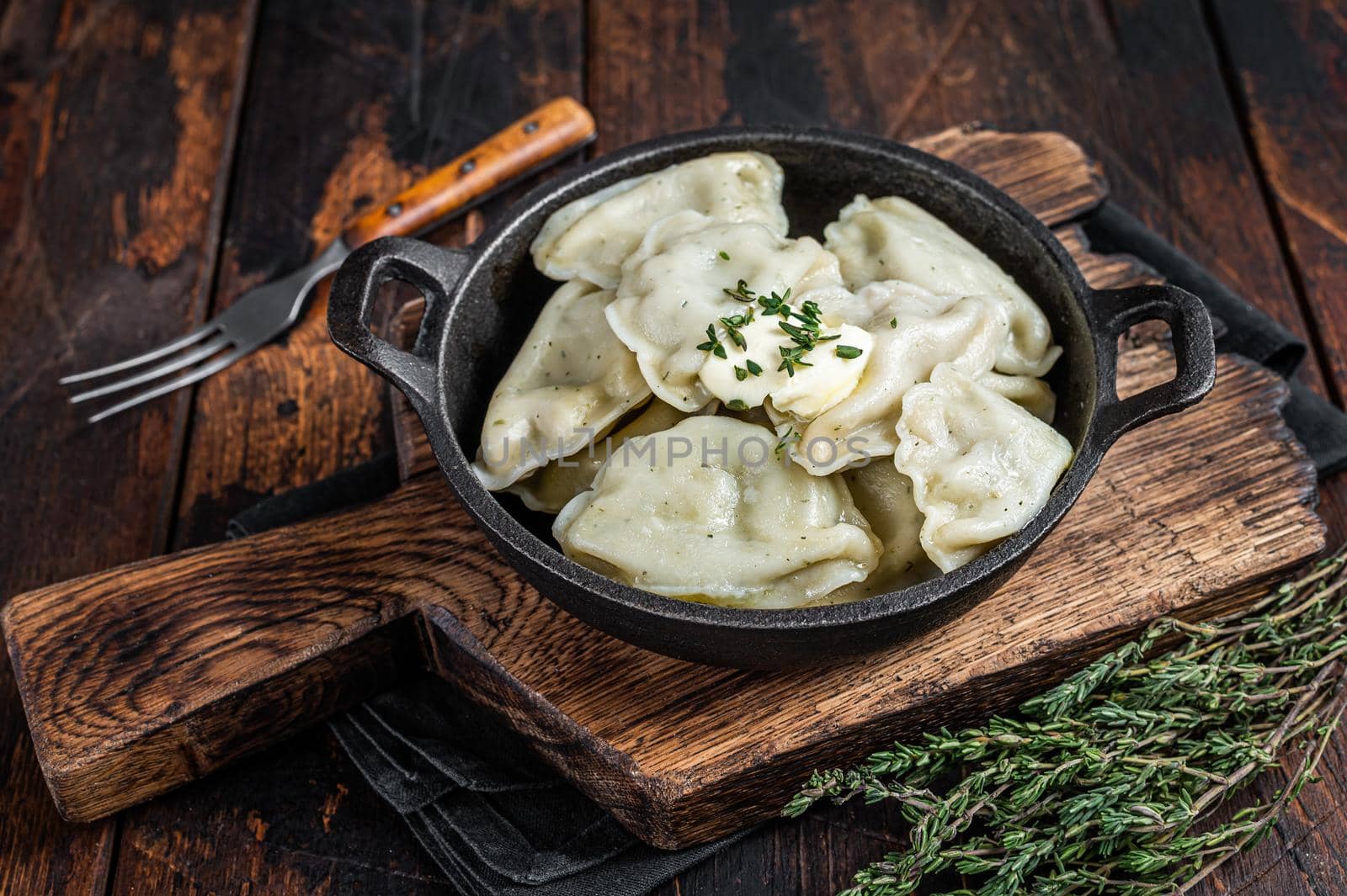 Homemade dumplings, vareniki, pierogi stuffed with potato in a pan. Dark wooden background. Top View by Composter