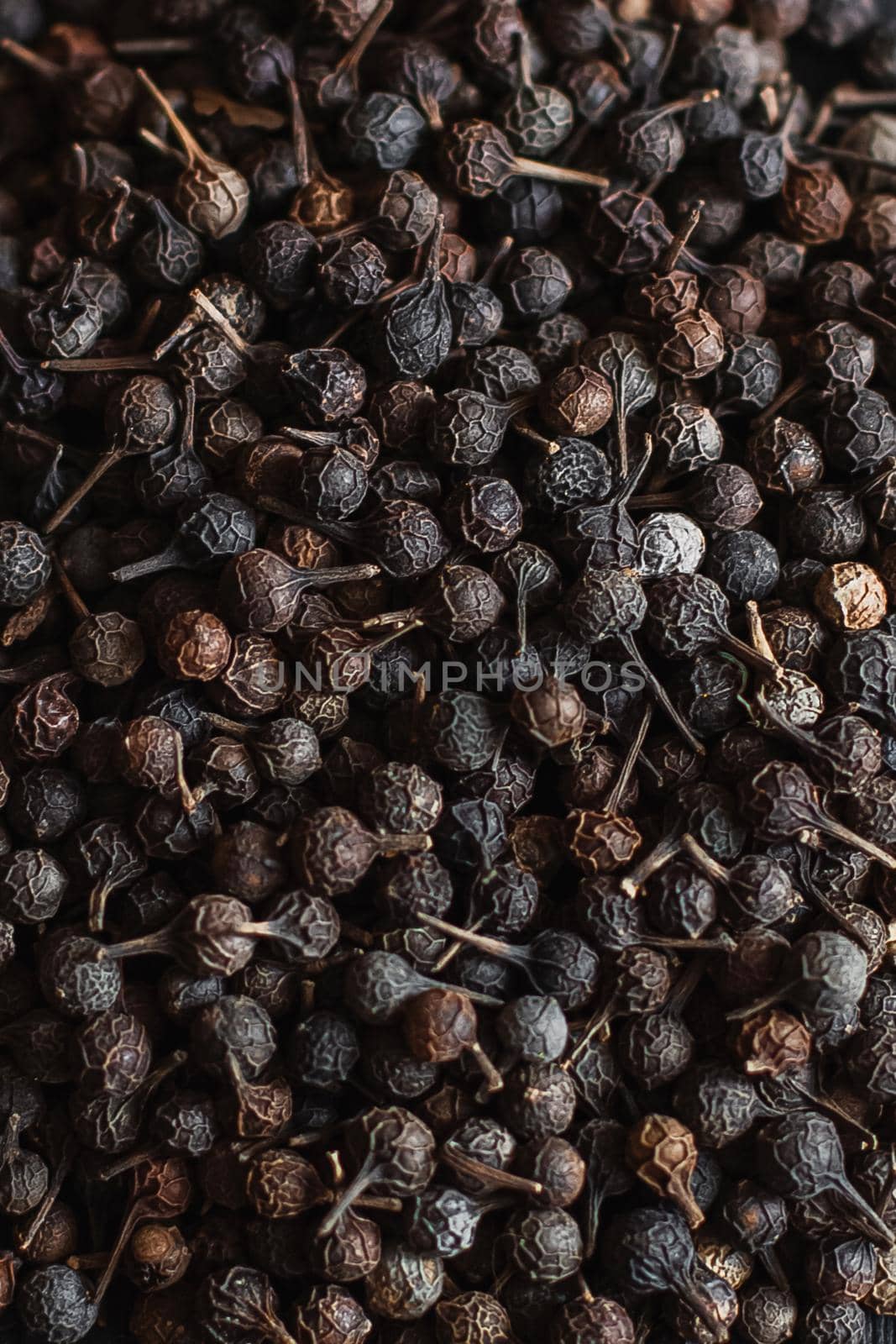 Black pepper grains, peppercorns seeds on a background close up macro