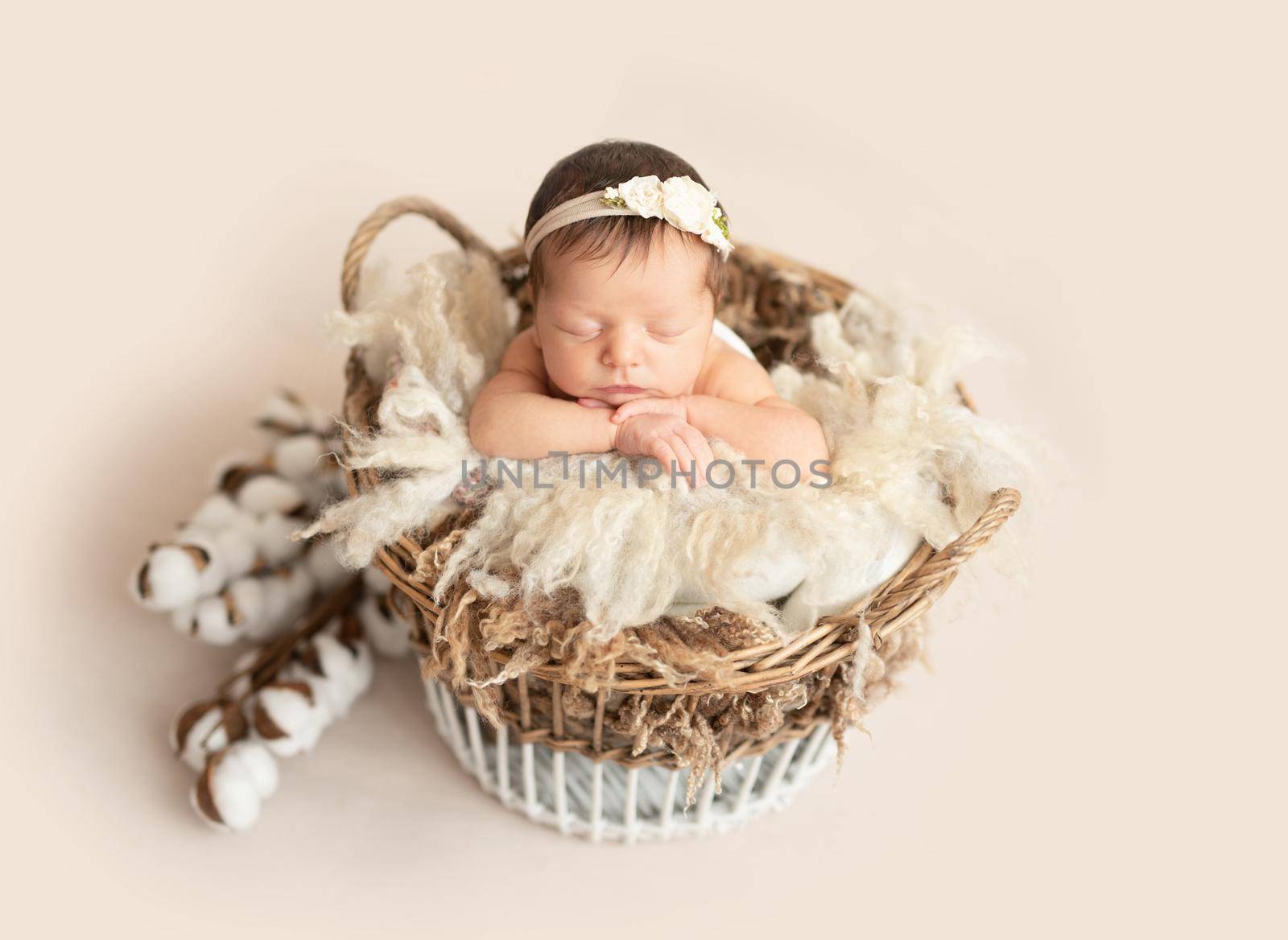 Cute sleeping newborn baby girl in the basket