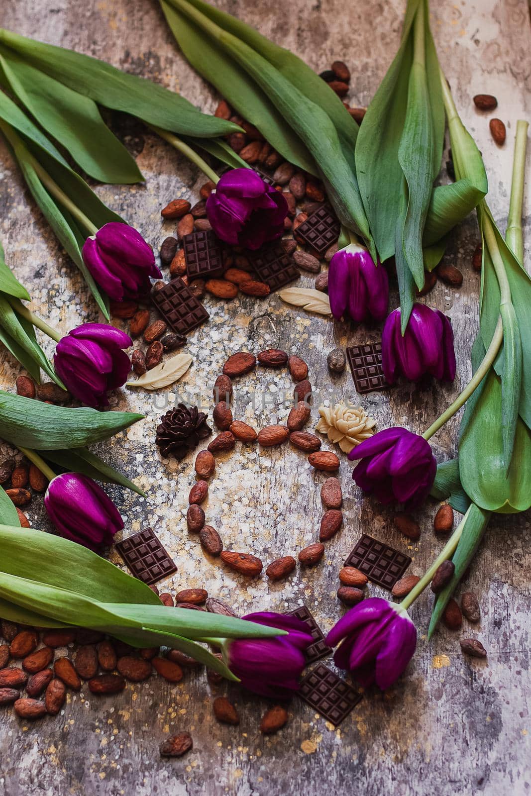 8 march, international woman's day, eight from cocoa beans with purple tulips and handmade chocolates around.