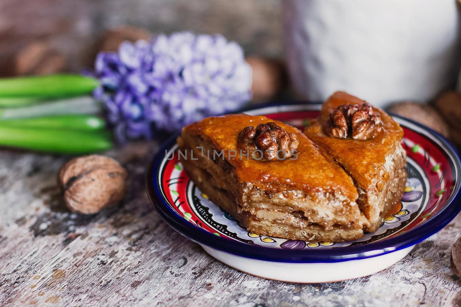 Assorted baklava. A Turkish ramadan arabic sweet dessert on a decorative plate, with coffee cup in the background. Middle eastern food baklava with nuts and honey syrup.