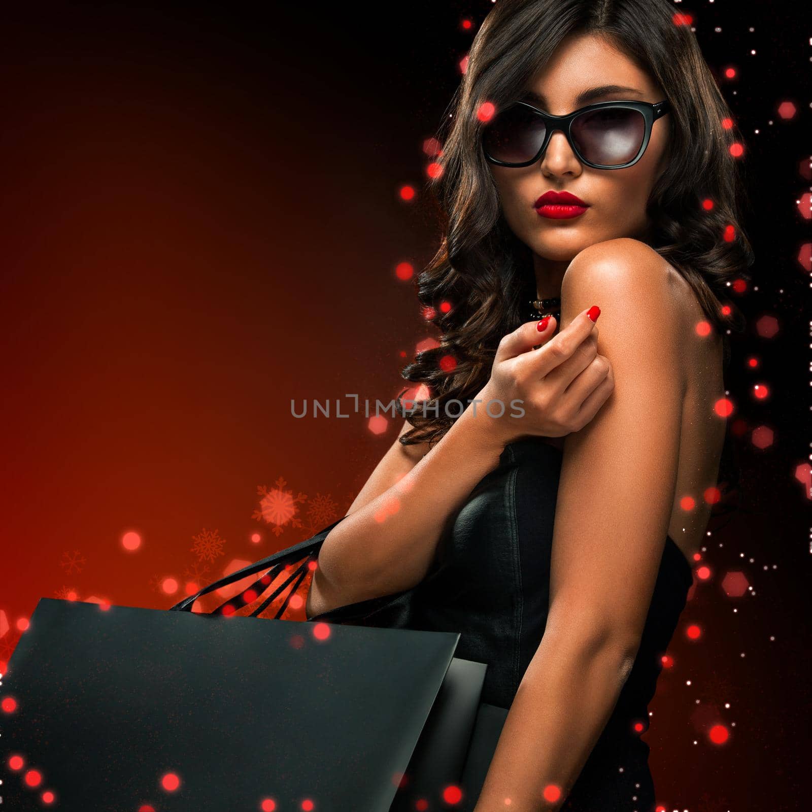 Black friday sale concept. Shopping woman holding grey bag isolated on dark background in holiday by MikeOrlov