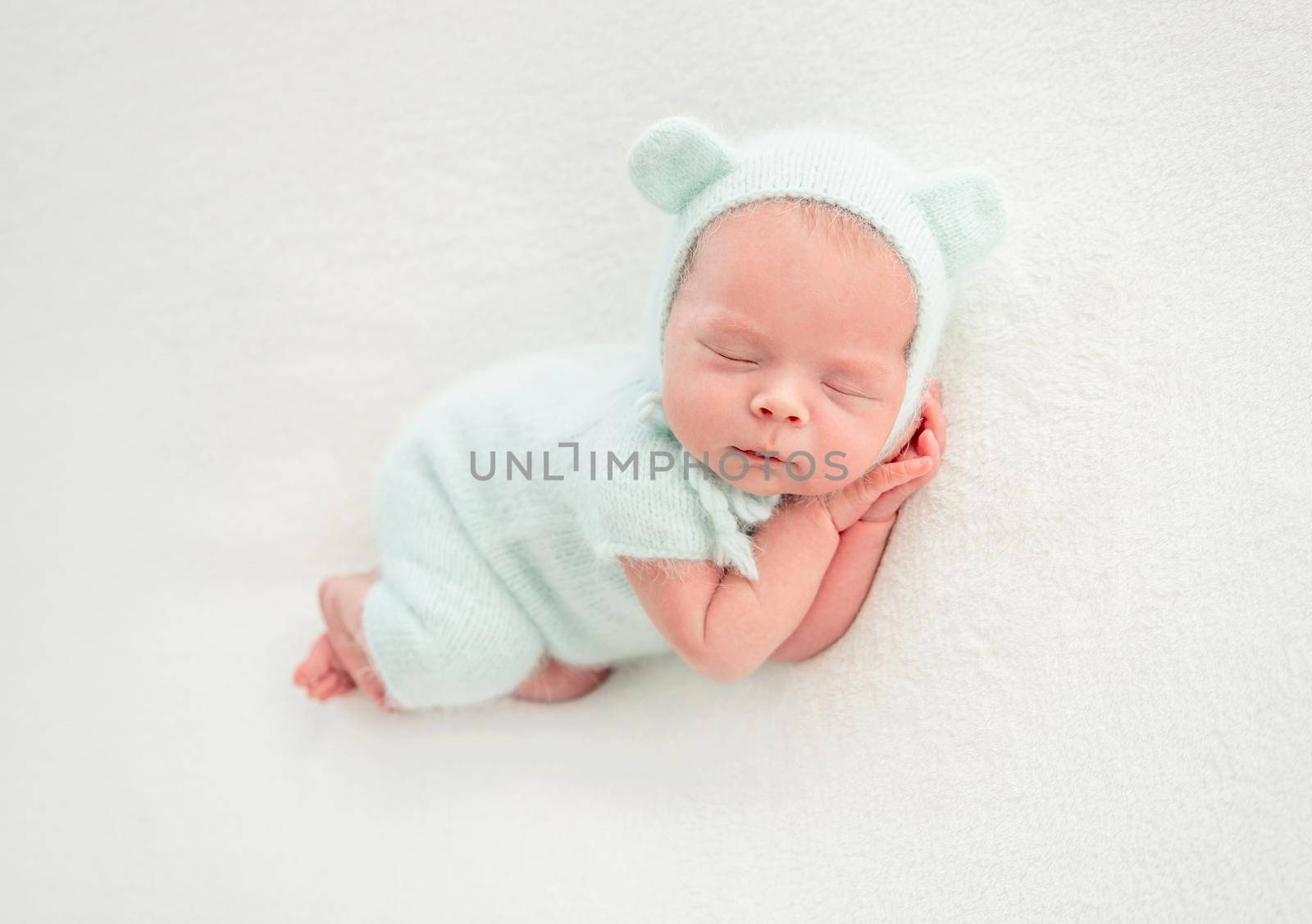 newborn baby girl sleeping sweetly in mint clothes