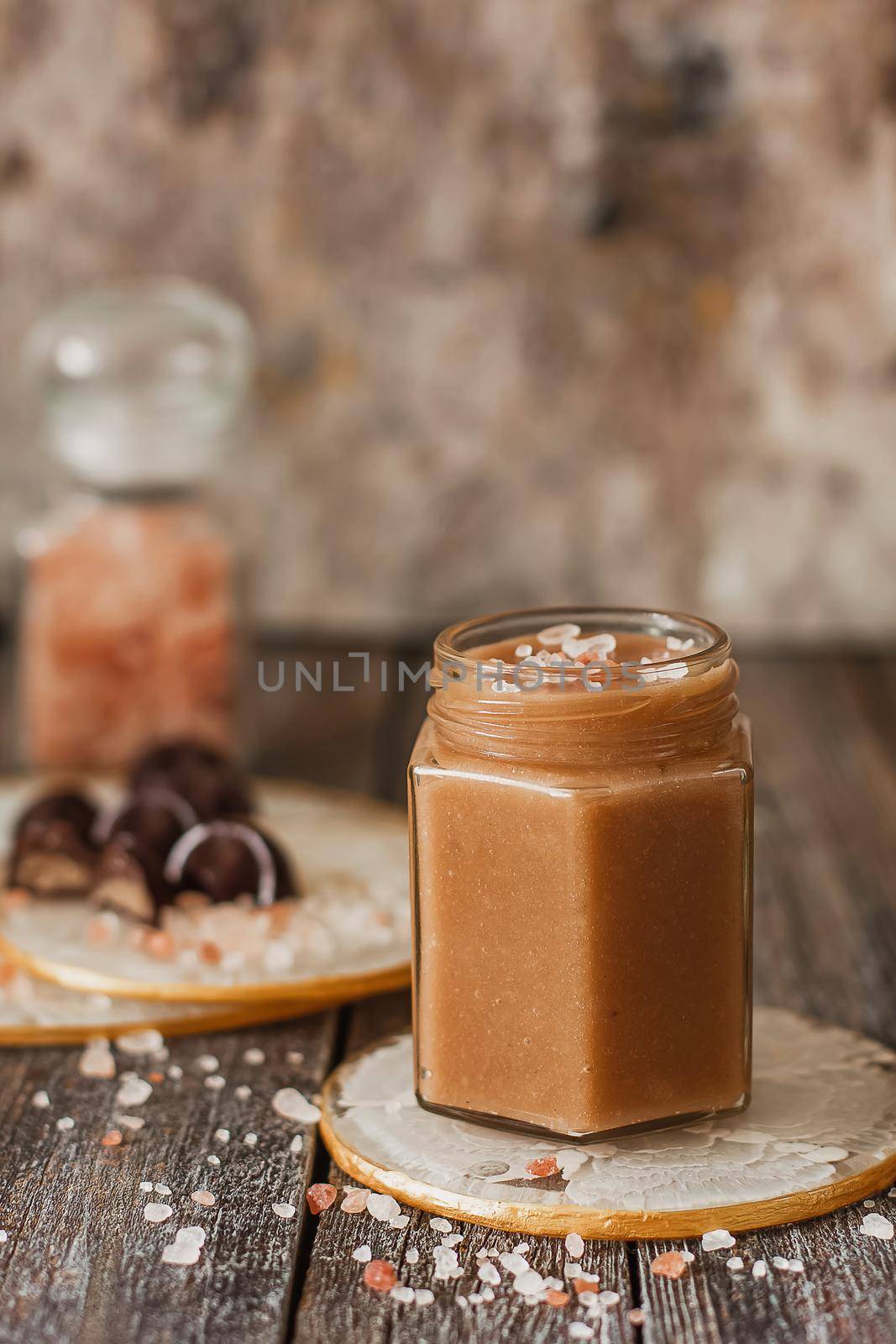 Homemade salted caramel sauce in jar on vintage background.