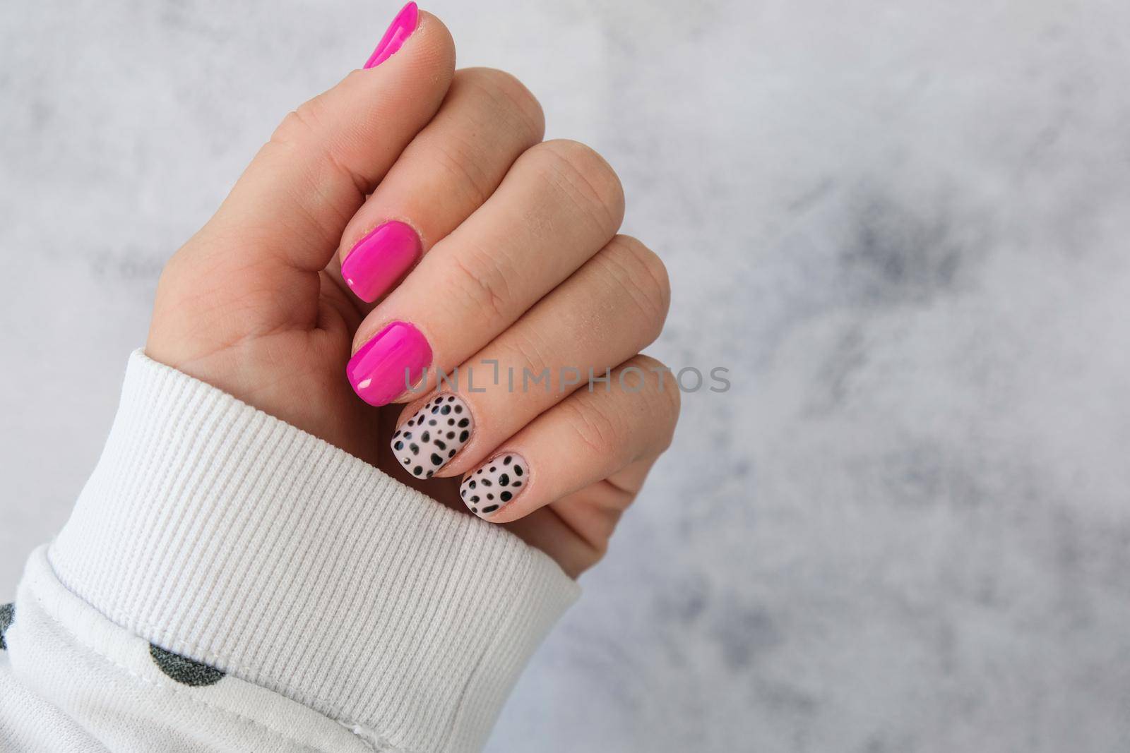 Manicured female hands with stylish pink nails and design. Trendy modern design manicure. Gel nails. Skin care. Beauty treatment. Nail care. Trendy colors by anna_stasiia