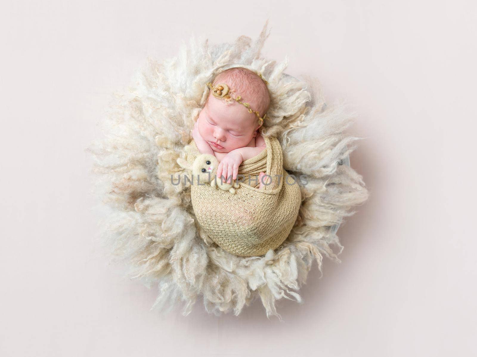 infant sleeping swaddled with rabbit toy, topview by tan4ikk1