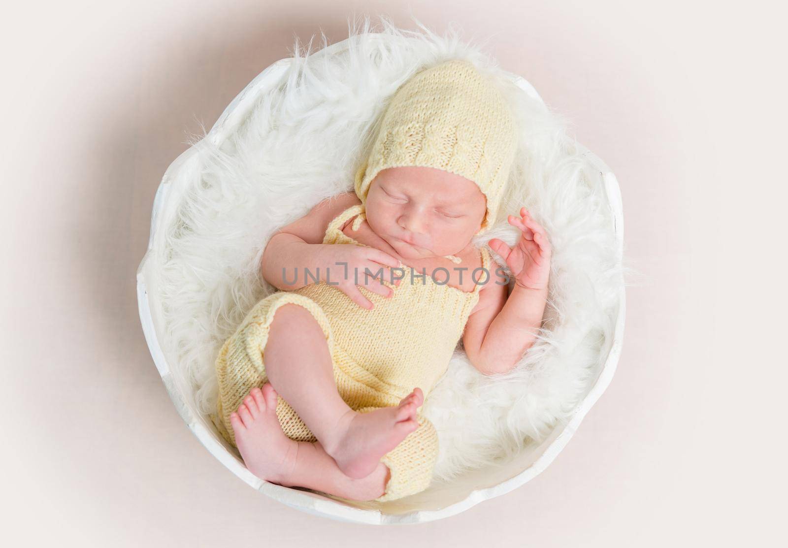 sweet newborn baby in hat and panties sleeping on the shell, top view