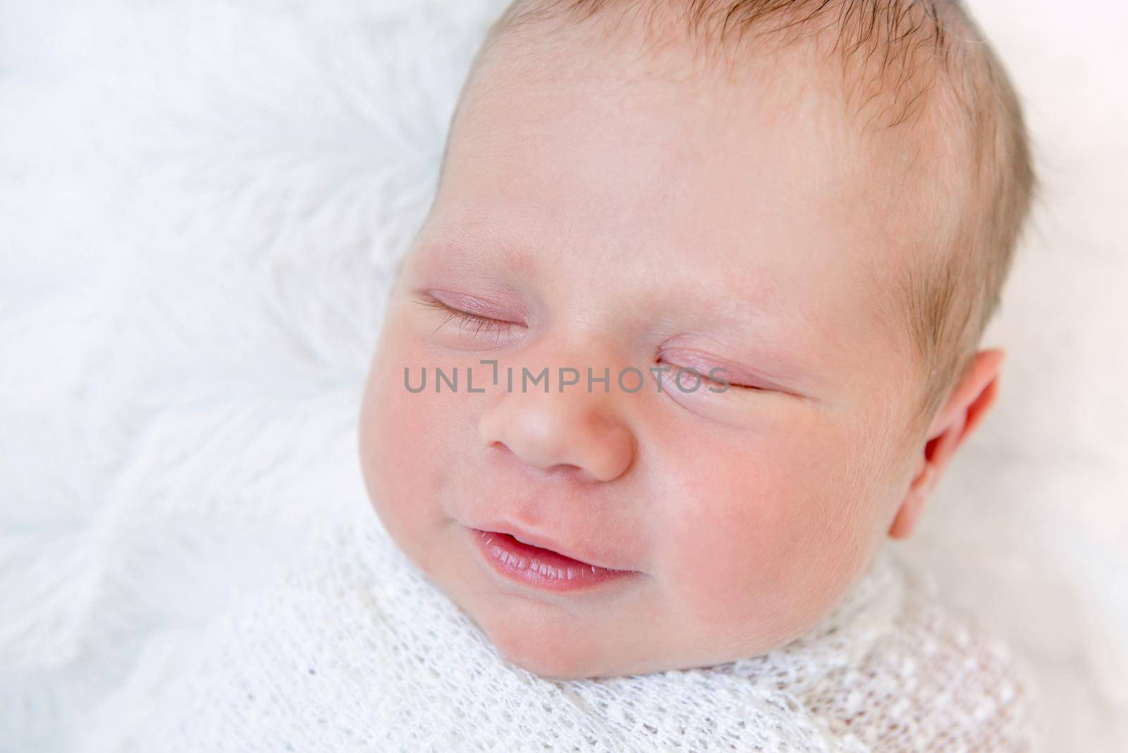 Close-up portrait of sleeping newborn baby. Swaddled newborn baby sleeping