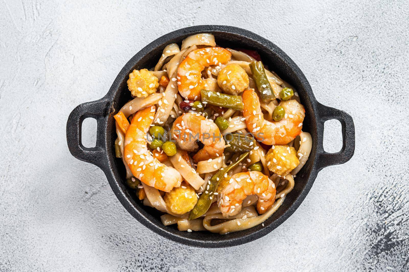 Udon stir-fry noodles with shrimps prawns in a pan. White background. Top view by Composter