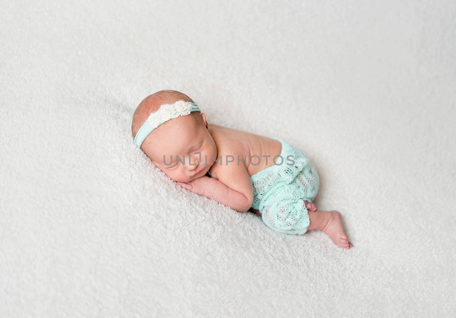 Sweet newborn girl sleeping and hugging her plush elephant toy. Little child girl sleeping with toy on soft rug