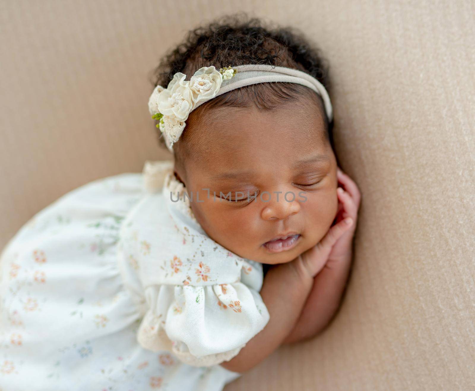 Cute African newborn baby sleeping head on her hands