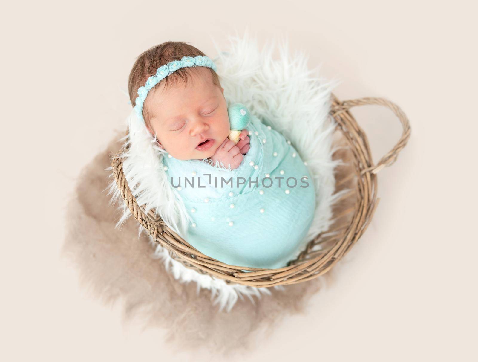 Adorable wrapped up newborn lying in basket