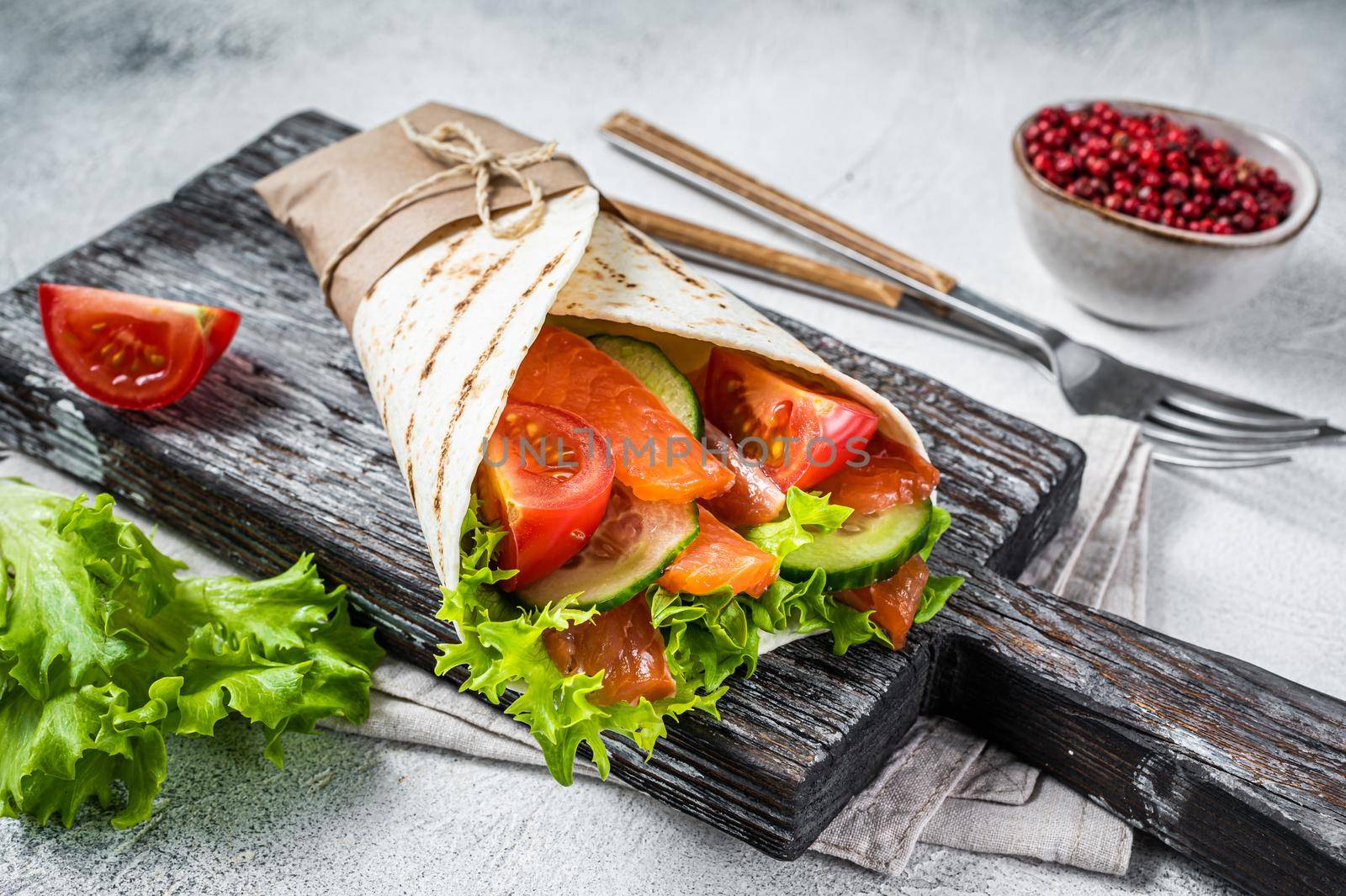 Wrap sandwich, roll with fish salmon and vegetables. White background. Top view by Composter