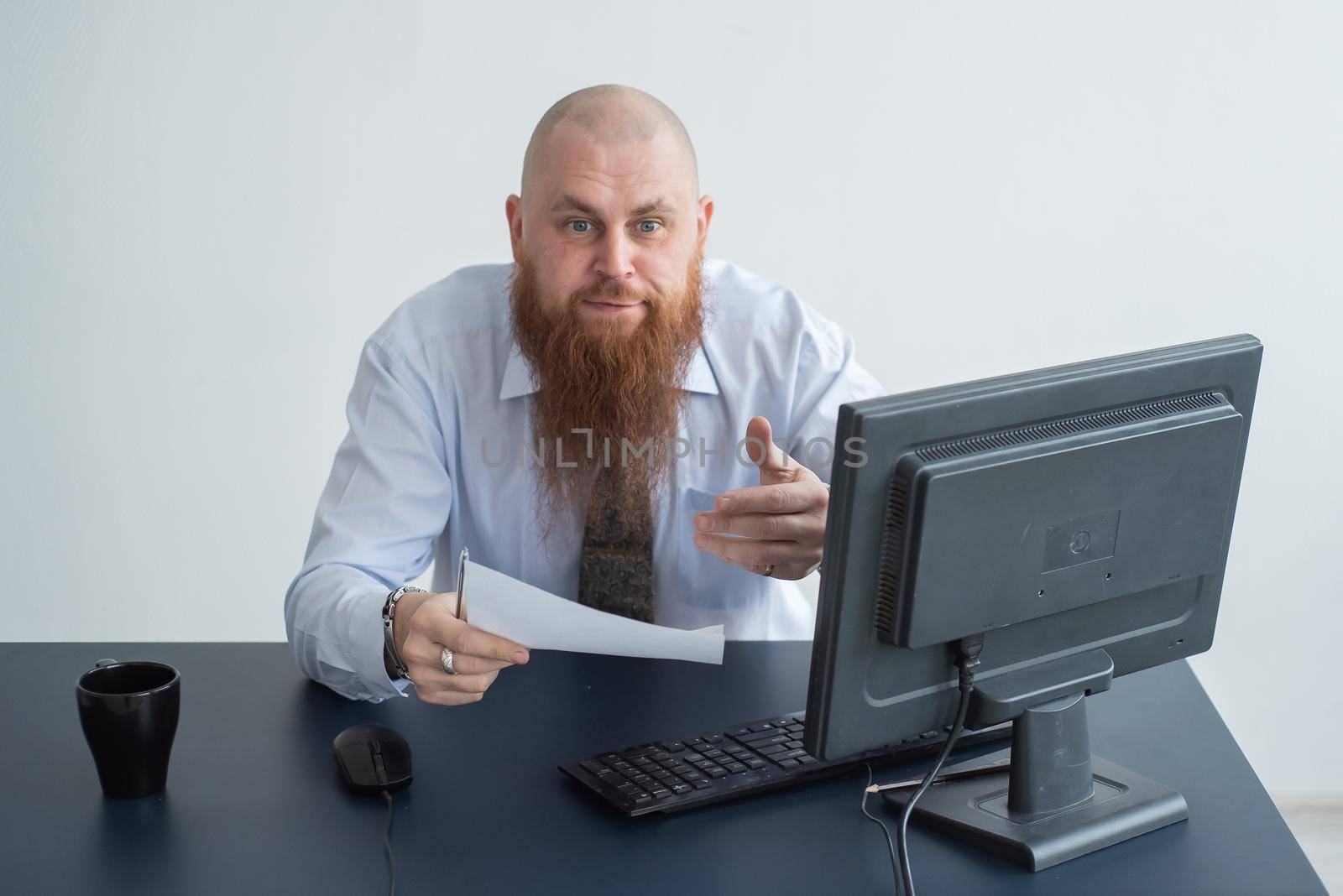 Portrait of a bald man at a desk looking at a report and cursing. The dissatisfied boss dismisses the subordinate