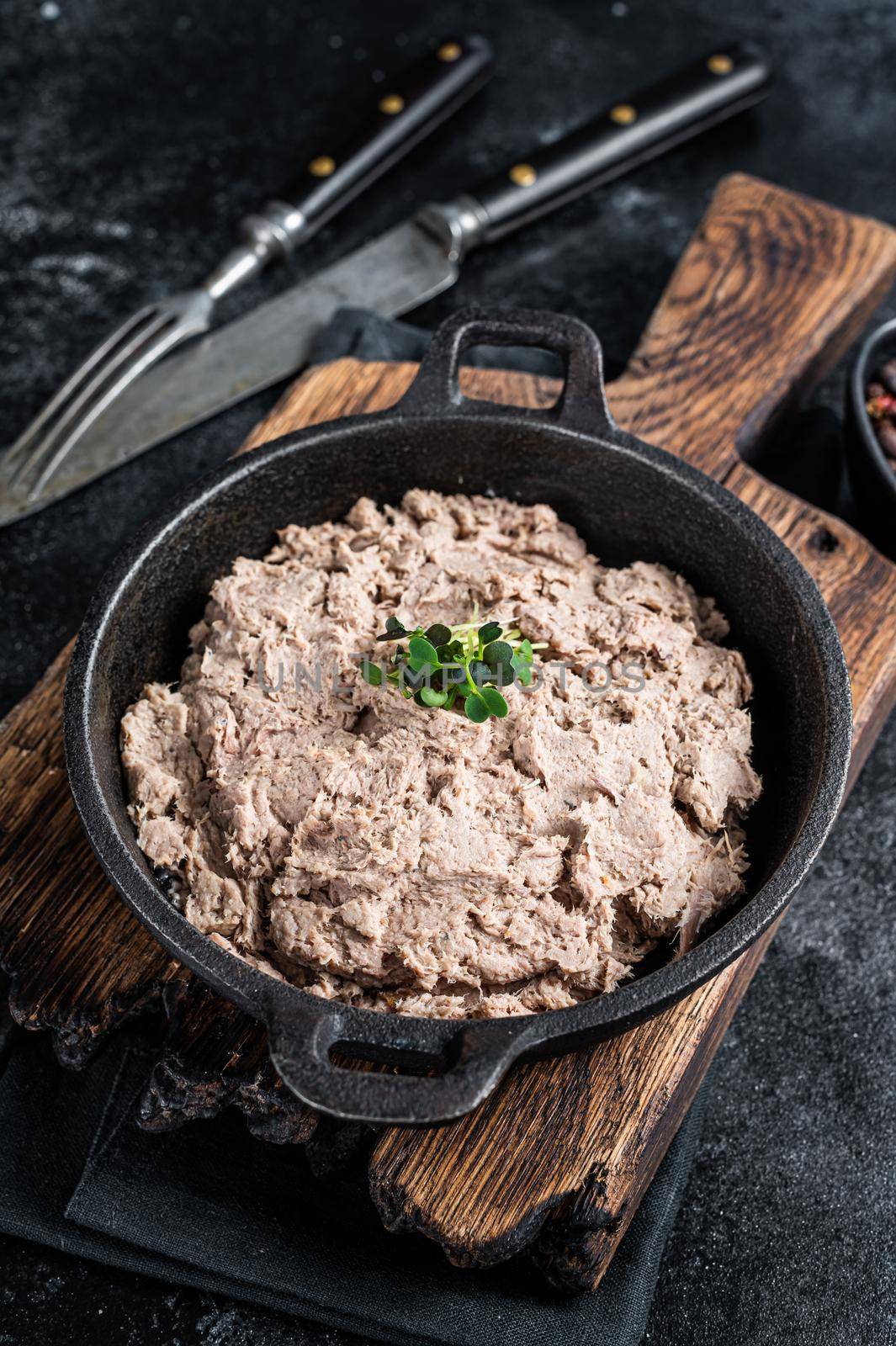 Duck pate Rillettes de Canard in a pan with greens. Black background. Top View by Composter