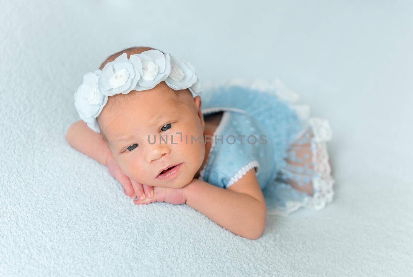 Cute newborn baby girl in a blue dress